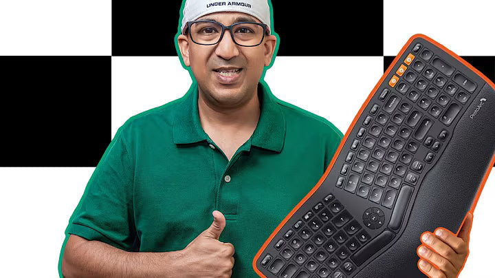 A person in a green shirt holding a large keyboard and giving a thumbs up.
