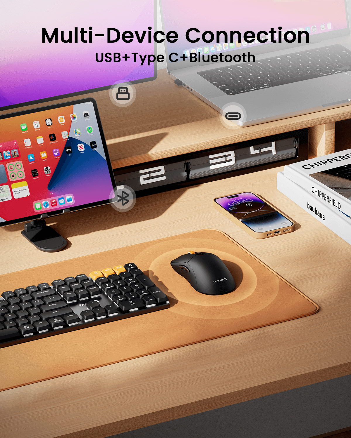 Black ergonomic EM15 wireless mouse with orange scroll wheel on a desk next to keyboard, smartphone, tablet, and laptop.