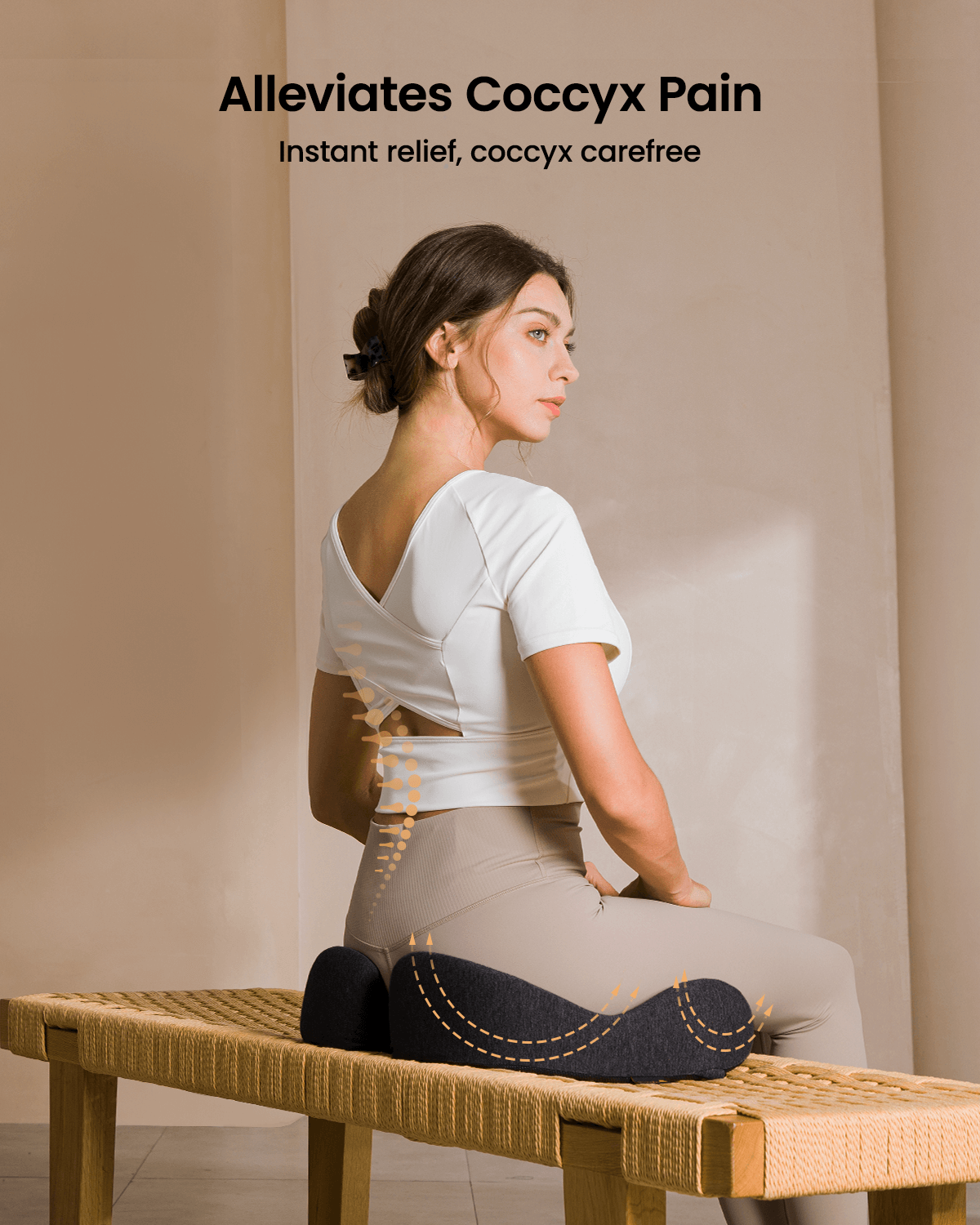 Woman sitting on a dark gray butterfly-shaped ergonomic seat cushion that alleviates coccyx pain.