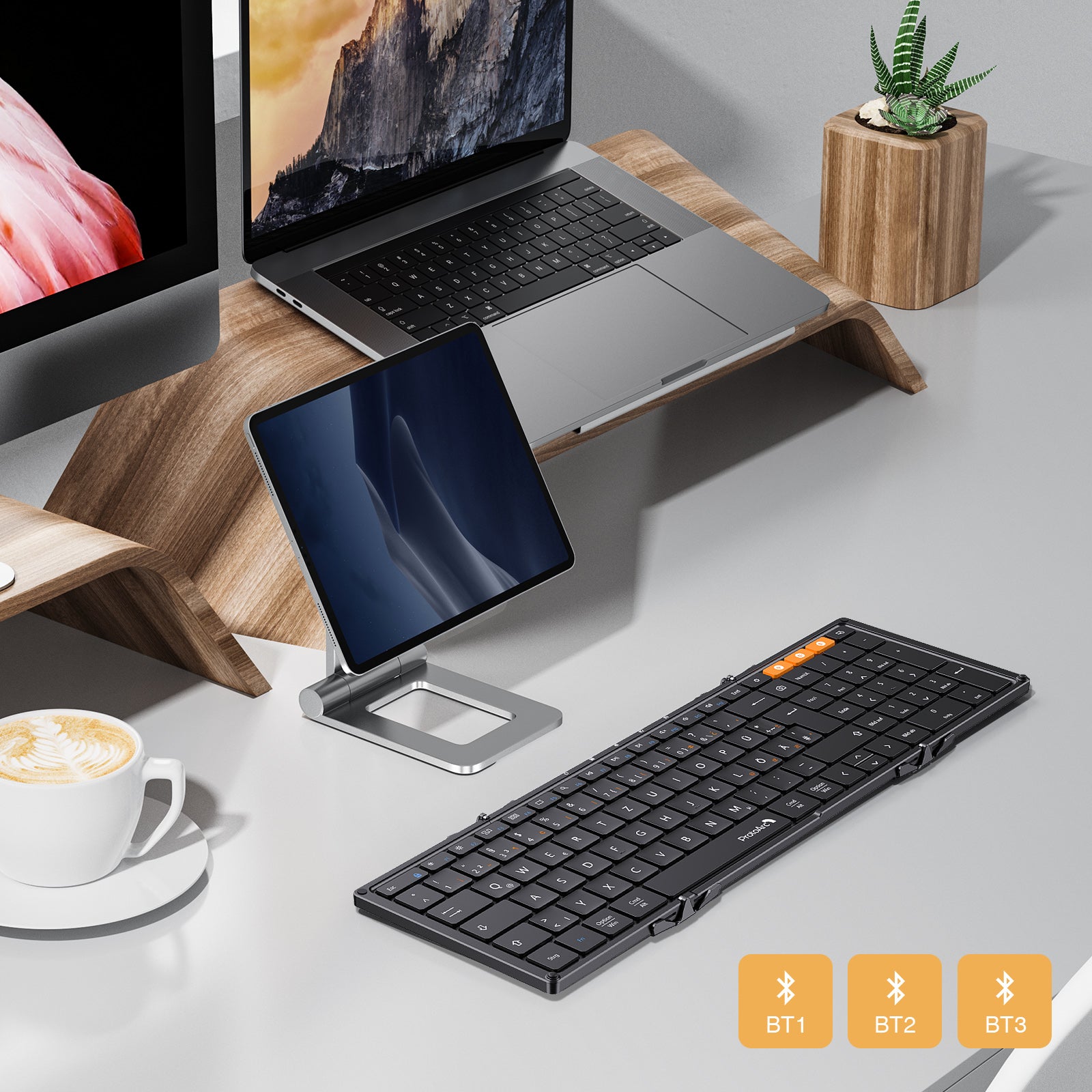Black XK01 tri-fold Bluetooth keyboard, DE layout, orange function keys, on desk with laptop and tablet.